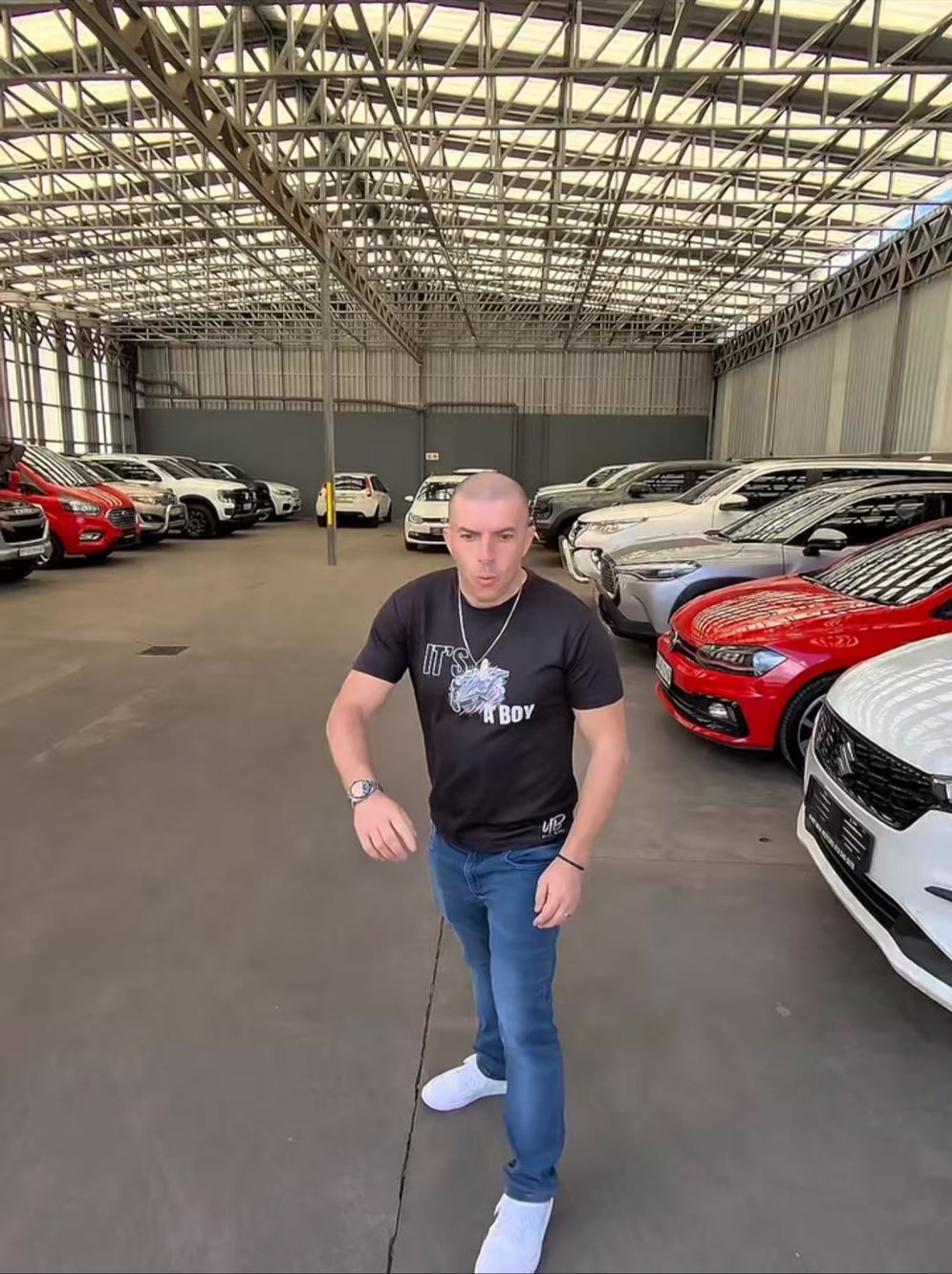 Uncle Bobby walking through a warehouse full of cars